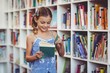 © WavebreakmediaMicro - School girl reading a book in library