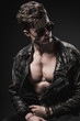 © AHetman - Beautiful athletic bodybuilder male model posing in studio. Expression on camera. Brutal man in leather suit.