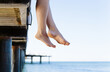 Woman's feet dangle from jetty