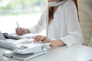 Canvas Print - Businesswoman with office IP telephone