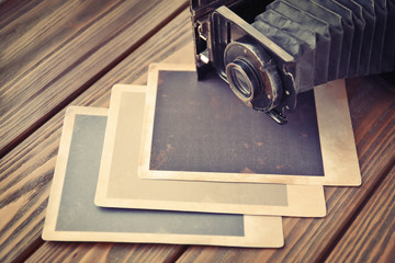 Wall Mural - Vintage photos with camera on wooden background