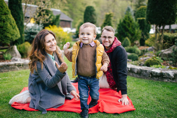 Happy young family, father mother and son on picnic outdoors