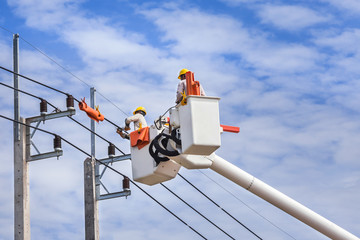 electrician repairing wire of the power line on basket hydraulic lifting platform vehicle  