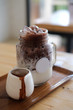 Pouring cocoa syrup on glass mug, iced cocoa menu.