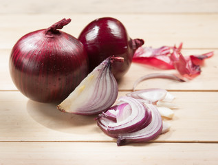 Wall Mural - Red onion and cutting board on wooden table, selective focus