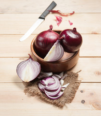 Wall Mural - Red onion and cutting board on wooden table, selective focus