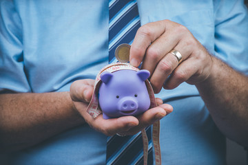 man holing money, money box, financial stress