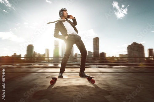 Fotografie, Obraz Geschäftsmann mit Smartphone auf Skateboard