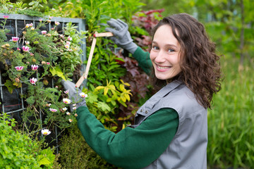 Young attractive landscaper woman working in a public park