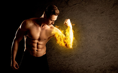 Muscular bodybuilder lifting weight with flaming biceps concept