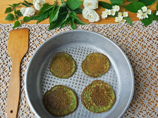 Nettles green pancakes with rose petals, cooking organic food with weed