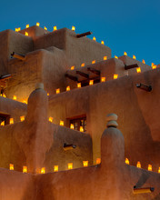 Large Adobe Building Decorated With Luminaria For The Holidays