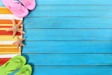 Summer beach background side border flip flops starfish couple sunbathing vacation holiday accessories on old weathered blue wood deck decking or boardwalk photo