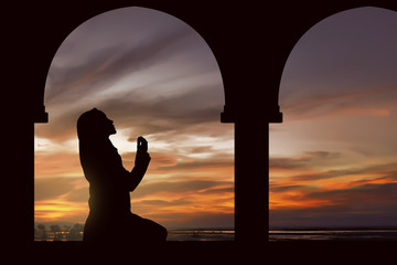 Silhouette of a women praying during sunset