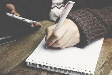 Wall Mural - woman hands with pen writing on notebook