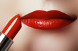 © looking2thesky - Extreme close up on model applying red lipstick. Make-up