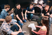 Musicians Learning New Song On The Floor. Top View On Music Band Members Sitting On The Floor With Song Text. Vocalist Smiling At Woman. Lifestile Of Young People Group. Teamwork.