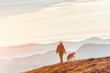 Man Walking With His Dog In The Mountains