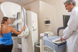 © jovannig - Female patient undergoing scan at mammography machine with male
