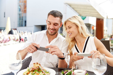 Wall Mural - happy couple with smatphone photographing food