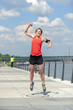 Jumping fit woman with arms up.