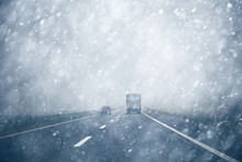 Car Overtaking A Truck On A Heavy Snowy, Rainy And Slippery Highway. Dangerous Overtaking At Bad Weather Condition.