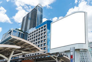 Blank white billboard on sunny city with building and blue sky.