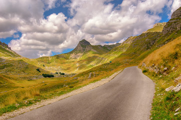 Wall Mural - Montenegro, national park Durmitor, road,mountains and clouds. Daytime sunlight landscape.