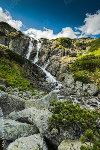 Fototapeta na wymiar Natural waterfall in high mountains