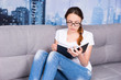 © kolotype - Pensive girl reading book and wearing  glasses