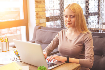 Wall Mural - Pretty blond girl typing on notebook