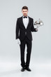 © Drobot Dean - Handsome young man waiter holding tray and lid