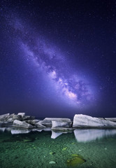 Wall Mural - Night landscape with colorful Milky Way at the sea with stones. Starry sky. Space background