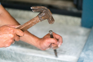 Carpenter is working with an old hammer and wedge
