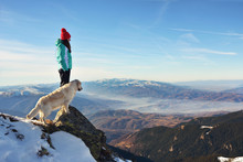 Girl With A Golden Retriever Dog On Top Of A Mountain During Winter Watching A Beautiful Landscape