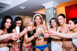 © Halfpoint - Cheerful bride and bridesmaids celebrating hen party with champa
