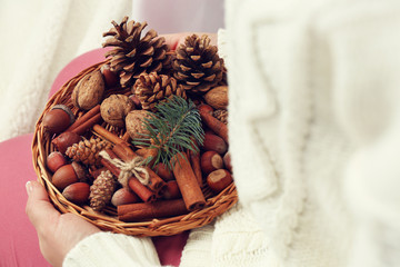 Wall Mural - Wicker basket with Christmas decoration in woman hands, closeup