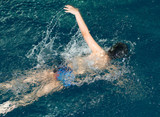 Fototapeta Łazienka - boy goes in for sports in the pool