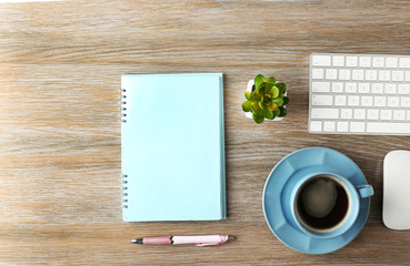 Canvas Print - Keyboard, notebook and cup of coffee on a wooden desk background, top view