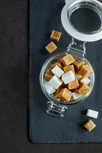 White And Brown Sugar Cubes In A Glass Jar