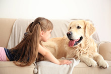 Little Girl And Big Kind Dog On Sofa