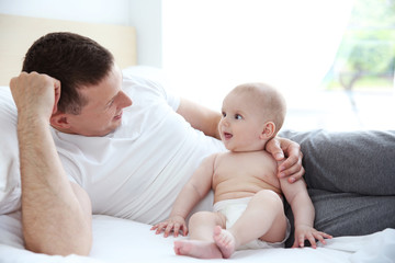 Wall Mural - Father with son lying on bed