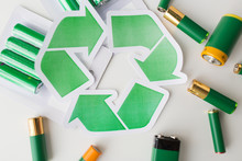 Close Up Of Batteries And Green Recycling Symbol