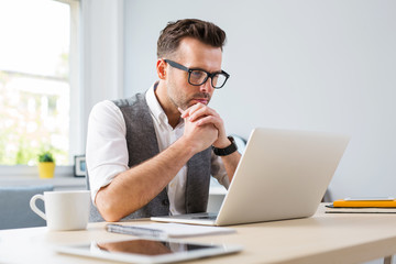 Canvas Print - Man in glasses working on laptop from home