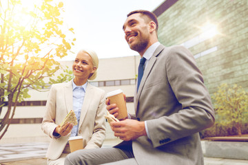 Canvas Print - smiling businessmen with paper cups outdoors