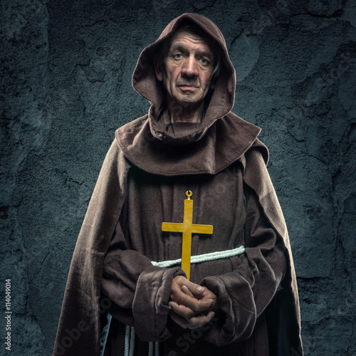 Fotomural Monk holding a wooden cross in front of the old walls