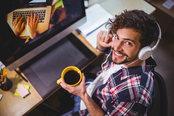 Portrait of happy creative businessman holding coffee cup