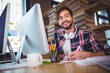 © WavebreakmediaMicro - Happy creative businessman writing in book at computer desk