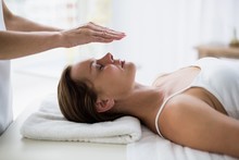 Cropped Hands Of Therapist Performing Reiki On Woman