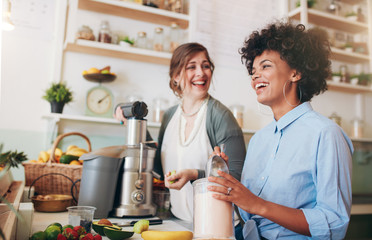 Wall Mural - Happy young women working at juice bar counter